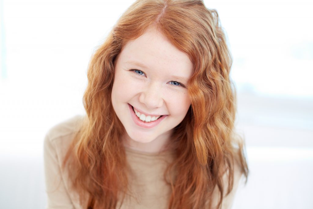 redheaded girl with freckles smiling