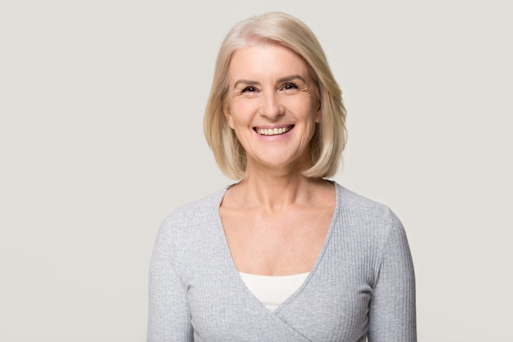 woman with short hair in gray sweater smiling