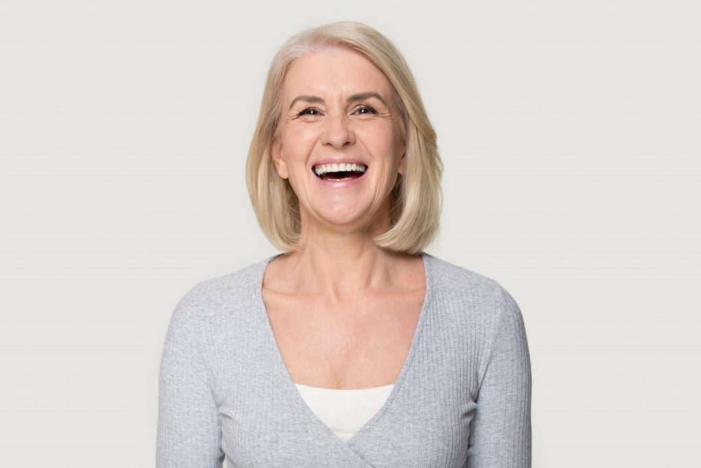 woman in gray sweater laughing