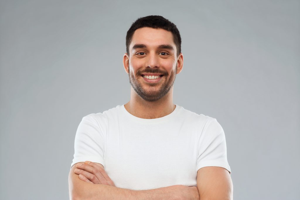 man in white shirt with crossed arms smiling